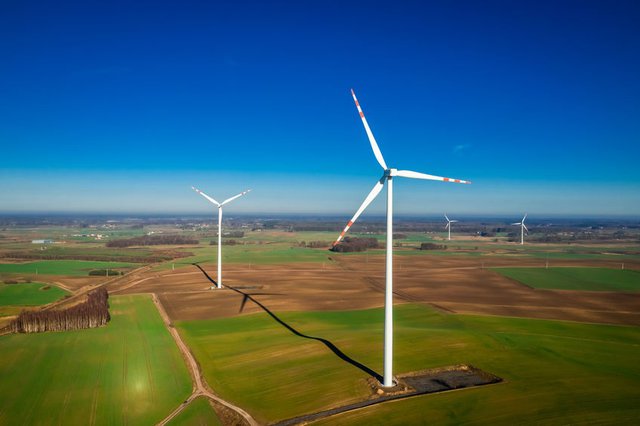 Aerial view of white wind turbines as pure energy